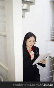 Businesswoman holding a newspaper and smiling