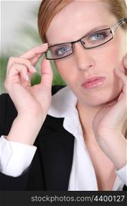 Businesswoman holding a pair of glasses