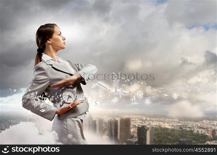 Businesswoman holding alarmclock. Image of young businesswoman holding alarmclock against illustration