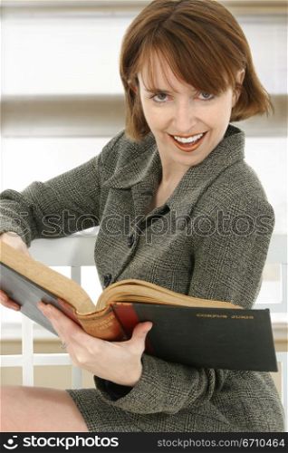 Businesswoman holding an accounts ledger and smiling