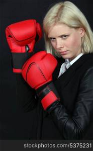 Businesswoman holding boxing gloves