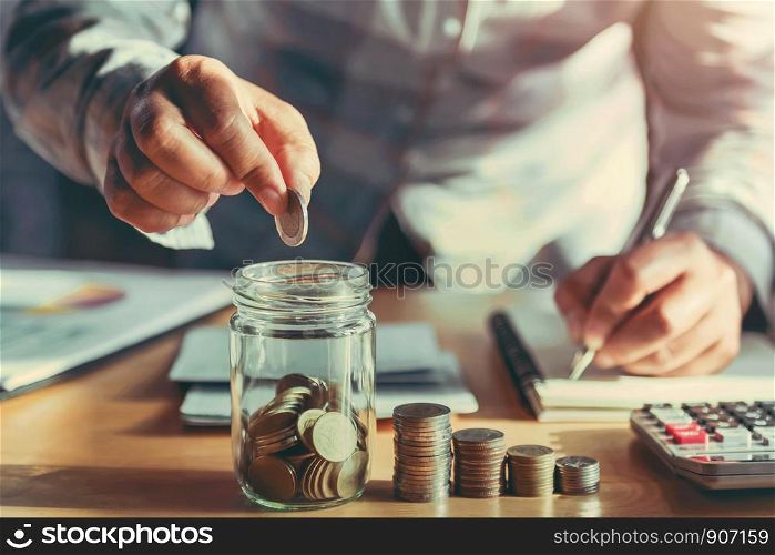 businesswoman holding coins putting in glass. concept saving money and finance accounting