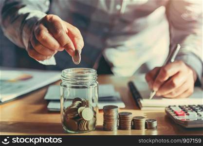 businesswoman holding coins putting in glass. concept saving money and finance accounting