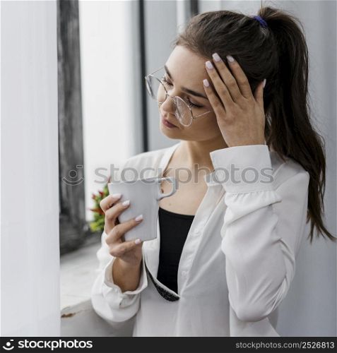 businesswoman holding cup coffee while working from home
