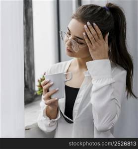 businesswoman holding cup coffee while working from home