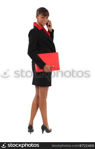 Businesswoman holding document folder and mobile