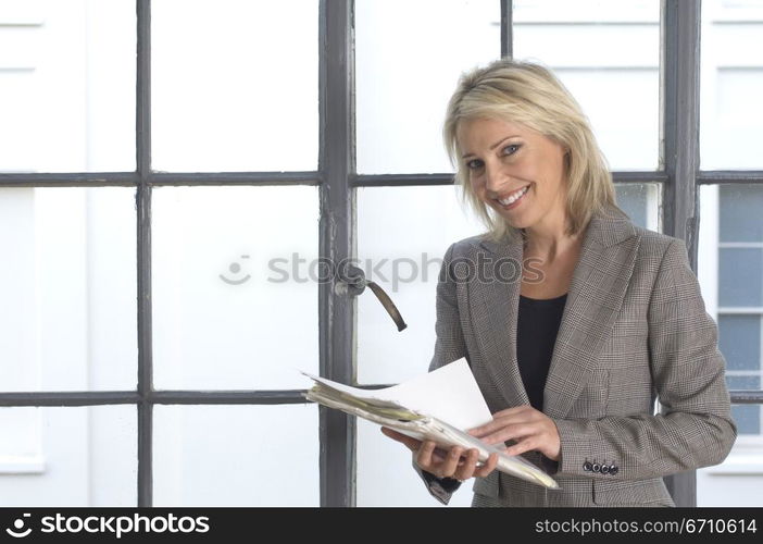 Businesswoman holding documents and smiling