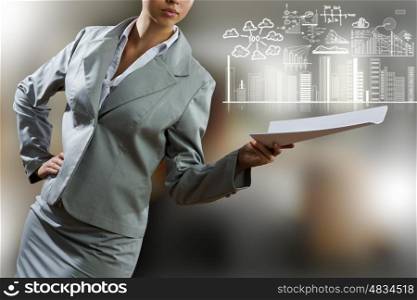Businesswoman holding documents. Close up of businesswoman with papers in hand