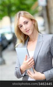 Businesswoman holding electronic tablet in town