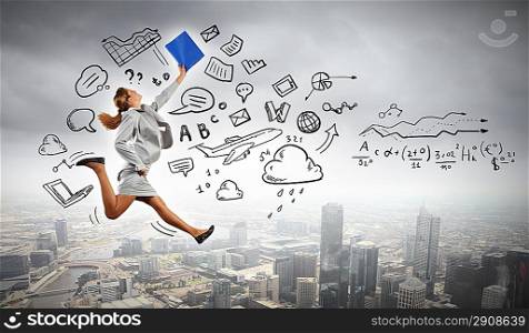 Businesswoman holding folder and jumping
