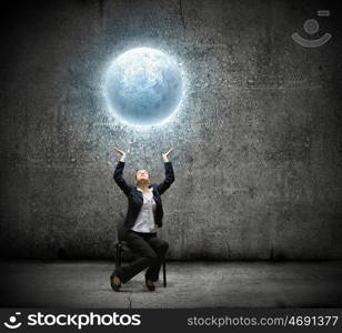 Businesswoman holding moon. image of businesswoman holding moon in hands above head