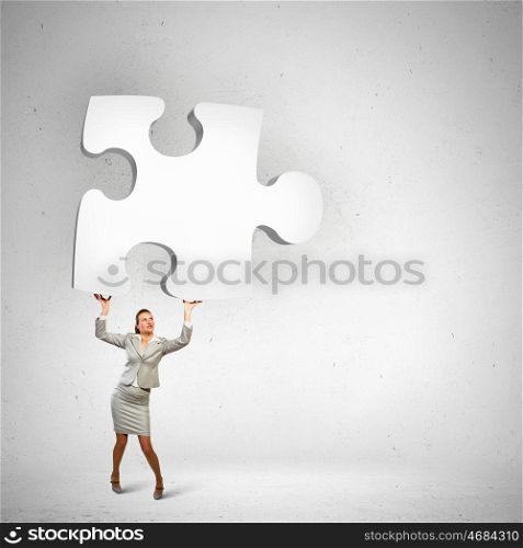 Businesswoman holding puzzle element. Image of businesswoman holding puzzle element above head