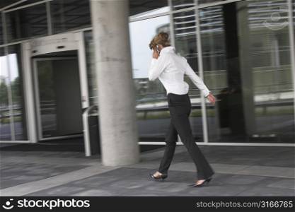 Businesswoman hurrying to her next appointment while talking on the phone (motionblur)