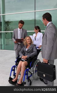 Businesswoman in a wheelchair with colleagues