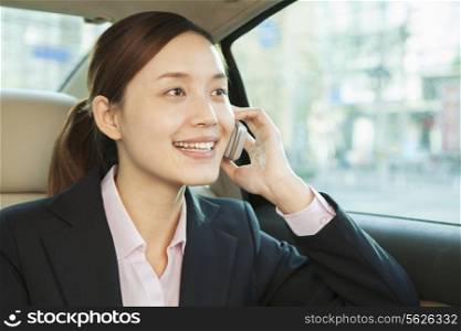 Businesswoman in Back Seat of Car on the Phone