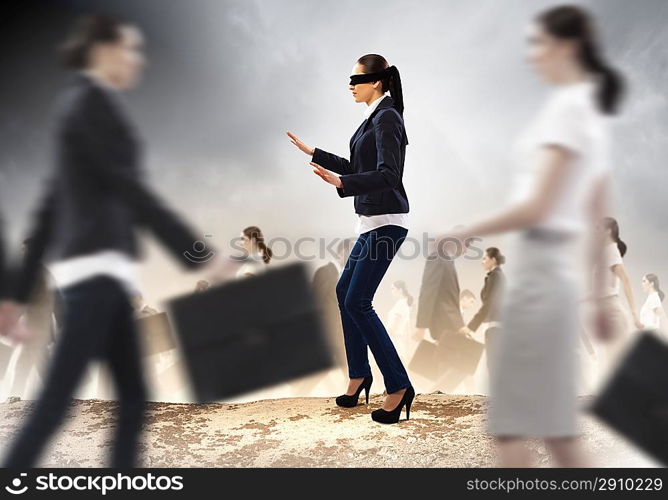 Businesswoman in blindfold among group of people