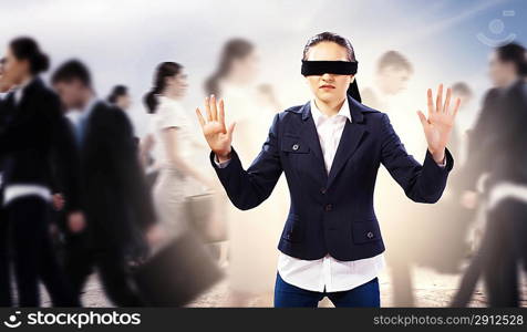 Businesswoman in blindfold among group of people