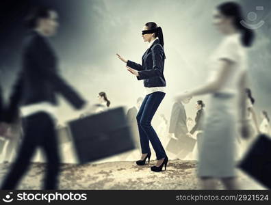 Businesswoman in blindfold among group of people