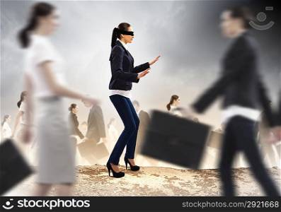 Businesswoman in blindfold among group of people