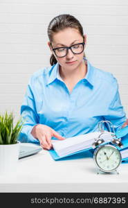 Businesswoman in blue shirt and glasses working with documents at office