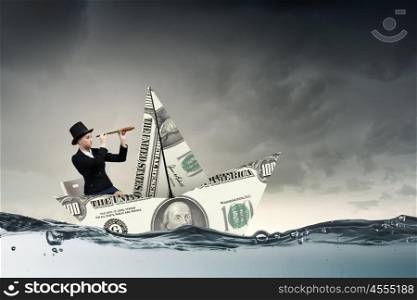 Businesswoman in boat made of dollar banknote. Successful businesswoman sailing on dollar boat in financial sea
