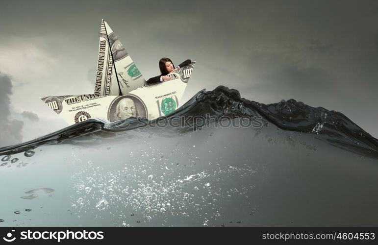 Businesswoman in boat made of dollar banknote. Successful businesswoman sailing on dollar boat in financial sea