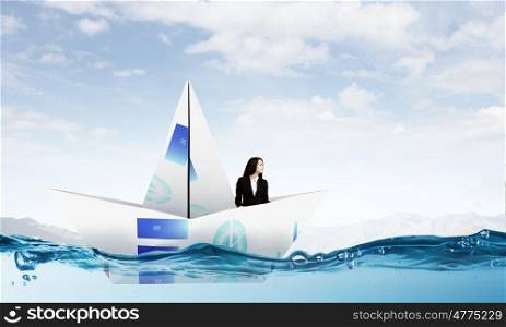 Businesswoman in boat made of paper. Successful businesswoman sailing on paper boat in financial sea