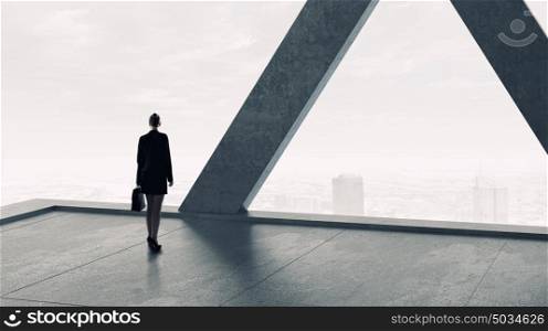 Businesswoman in building interior. Businesswoman in modern interior standing with back and looking in window