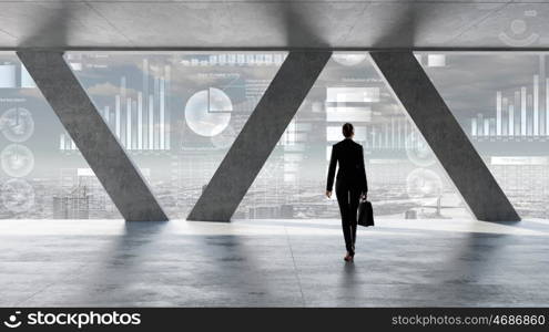 Businesswoman in building interior. Businesswoman standing with back and looking in office window