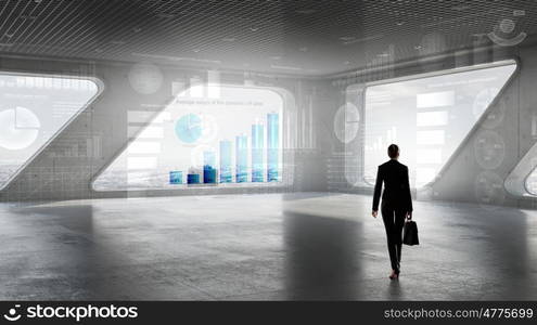 Businesswoman in building interior. Businesswoman standing with back and looking in office window