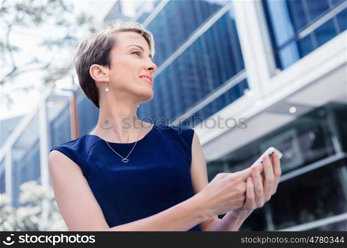 Businesswoman in city holding her mobile. Technology is a part of my life