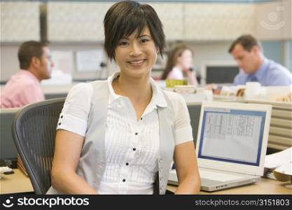 Businesswoman in cubicle smiling