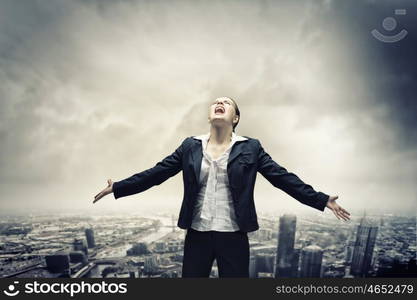 Businesswoman in despair. Image of businesswoman on top of building screaming