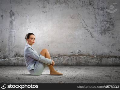 Businesswoman in despair. Image of young upset businesswoman sitting alone