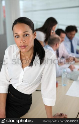 Businesswoman in front of a busy team