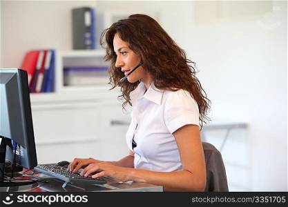 Businesswoman in front of computer with headset on