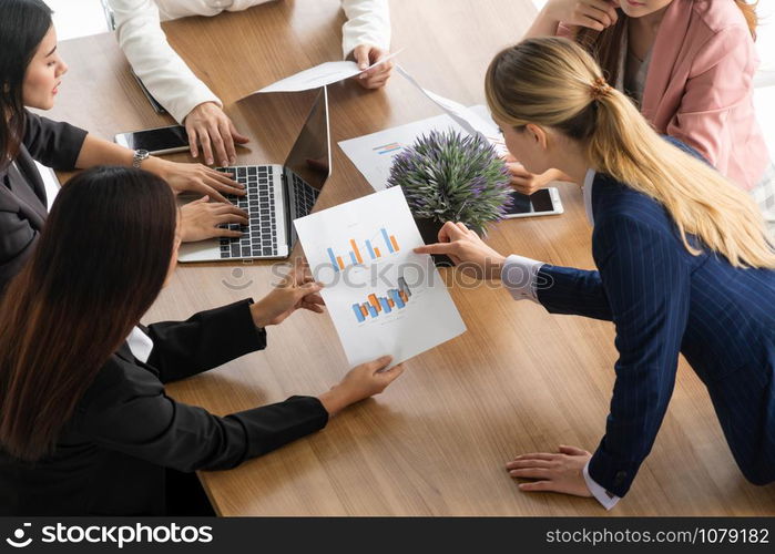 Businesswoman in group meeting discussion with other businesswomen colleagues in modern workplace office with laptop computer and documents on table. People corporate business working team concept.