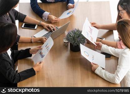 Businesswoman in group meeting discussion with other businesswomen colleagues in modern workplace office with laptop computer and documents on table. People corporate business working team concept.