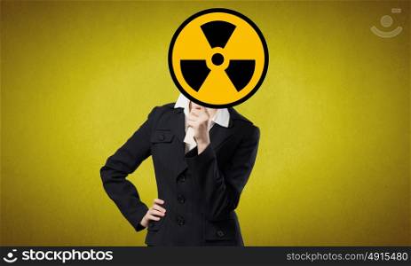 Businesswoman in mask. Unrecognizable businesswoman hiding her face behind radioactivity sign