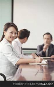 Businesswoman in Meeting Smiling At Camera