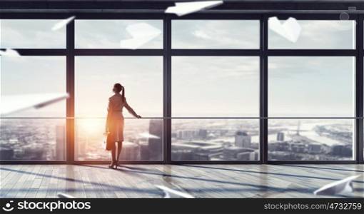Businesswoman in modern office interior. Young successful businesswoman thinking about future of her company