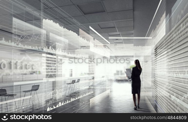 Businesswoman in modern office interior. Young successful businesswoman thinking about future of her company