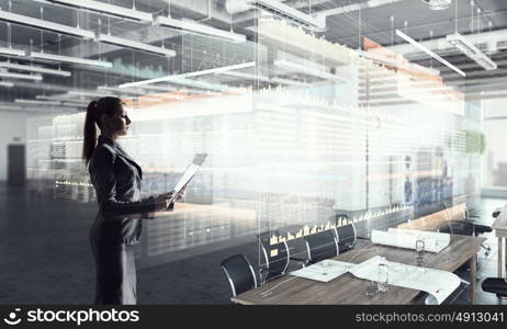 Businesswoman in modern office interior. Young successful businesswoman thinking about future of her company