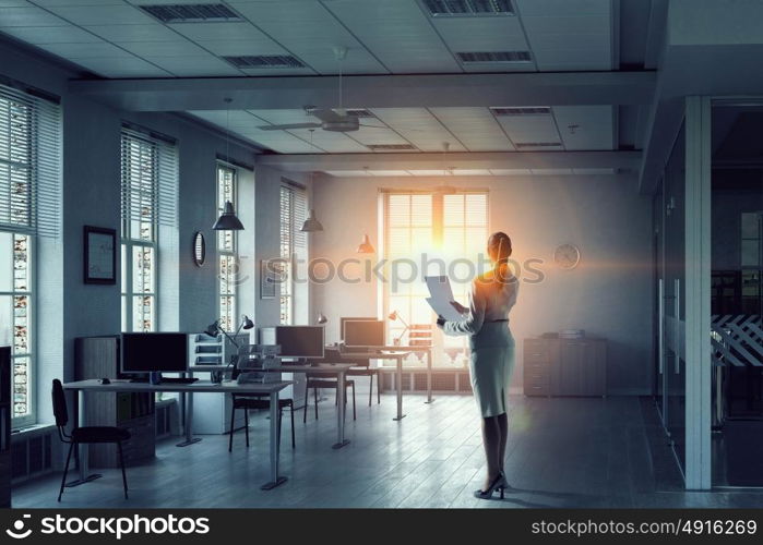 Businesswoman in modern office interior. Young successful businesswoman thinking about future of her company