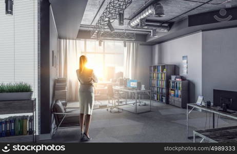 Businesswoman in modern office interior. Young successful businesswoman thinking about future of her company