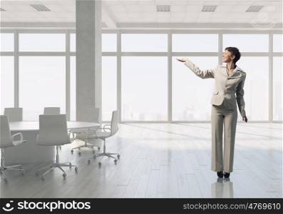 Businesswoman in office mixed media. Young successful businesswoman in white office interior