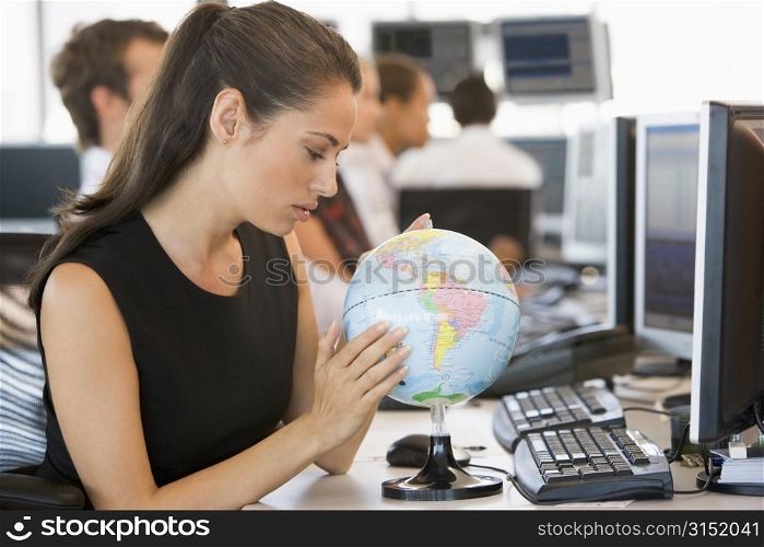 Businesswoman in office space with desk globe