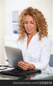 Businesswoman in office using electronic tab