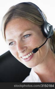 Businesswoman in office wearing headset and smiling