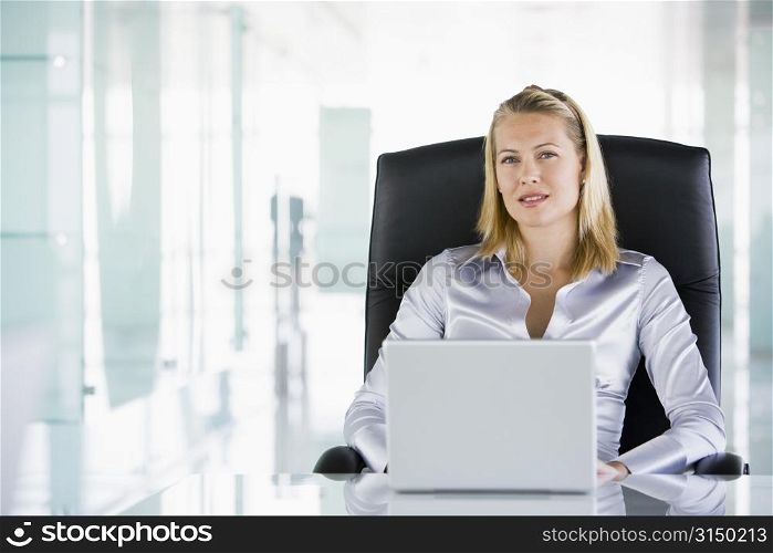 Businesswoman in office with a laptop